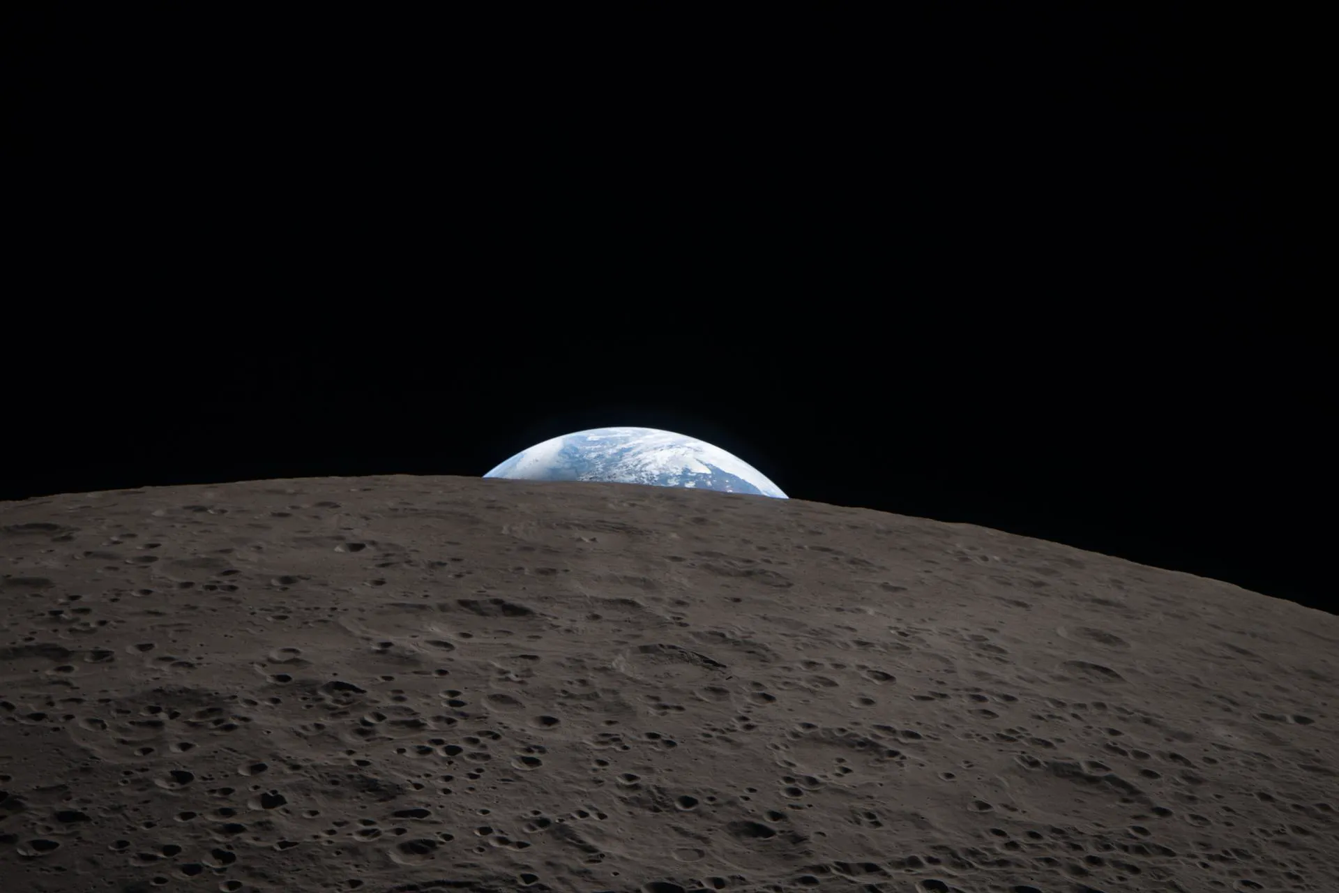 Jorden som går ned bak den kraterfylte randen på månens bakside, fotografert fra Orion under Artemis II-passeringen