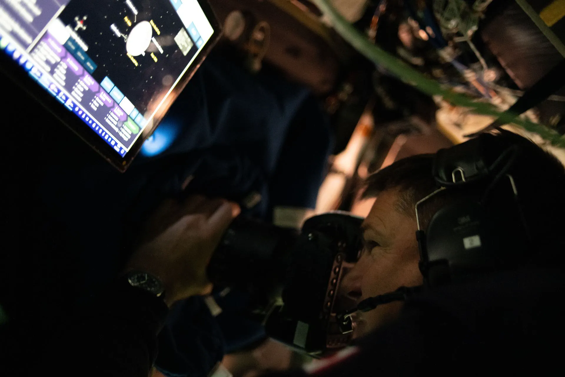CSA-astronauten Jeremy Hansen som fotograferer månen gjennom et Orion-vindu