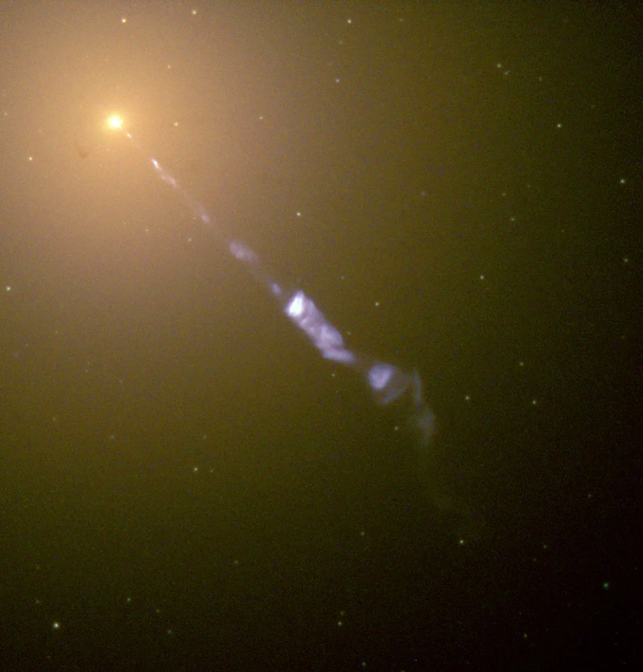 En smal blåhvit plasmastråle som strømmer ut av den lyse kjernen i den elliptiske galaksen M87