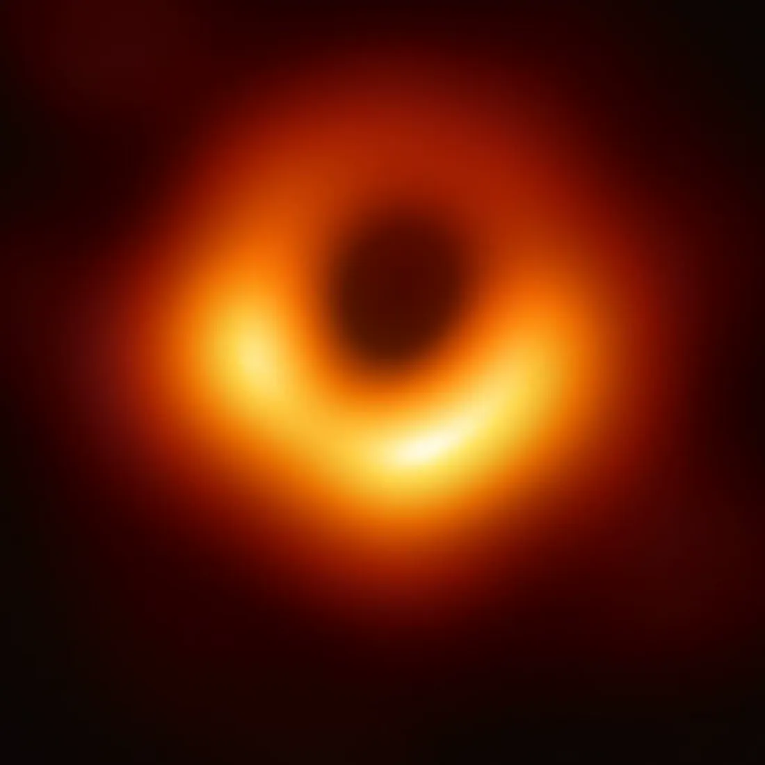 Det første fotografiet av et sort hull: en uskarp oransje ring, lysere langs nedre kant, rundt et mørkt sentrum