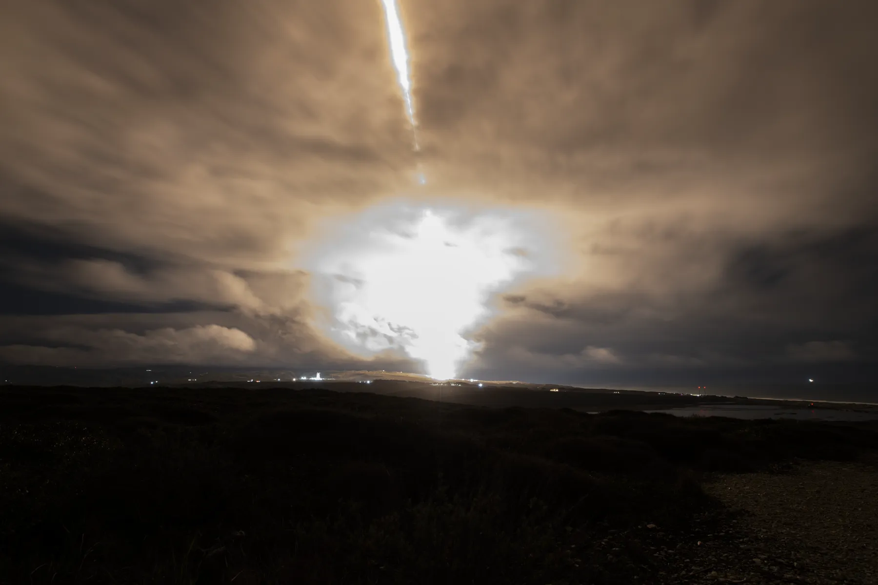 Langtidseksponering av en Falcon 9-oppskyting som trekker en lysstripe over nattehimmelen