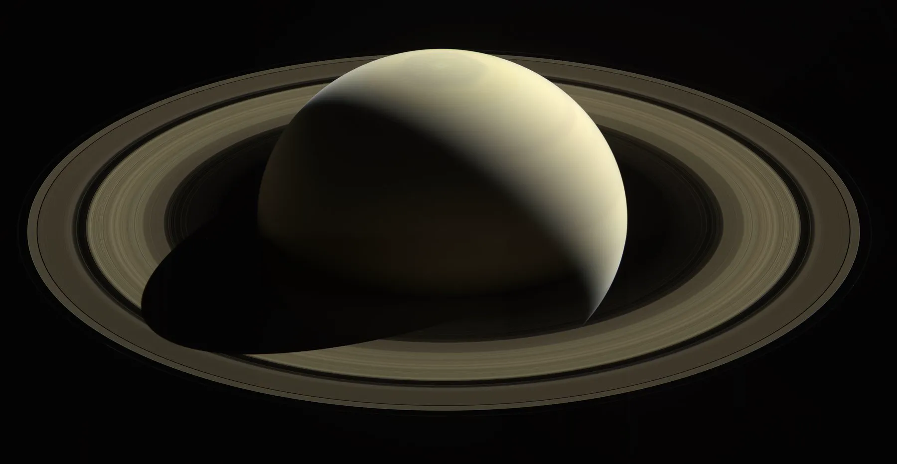 Saturn, bakbelyst av solen
